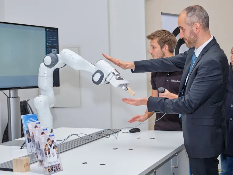 Zwei M&auml;nner mit Industrieroboter